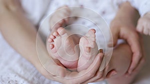 Baby`s feet in mom`s hands close up