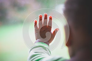 Baby`s fingers on window