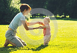 Baby`s first steps. Mother and child in nature