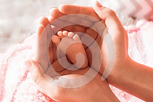 baby's foot in mother's hands