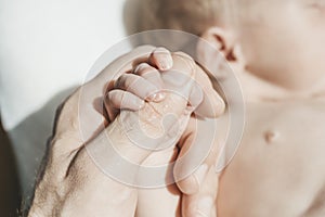 Baby& x27;s hand. The father holds with tenderness and love the small hand of the newborn. New life, parental protection