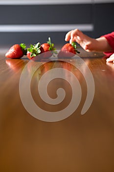 Baby s hand manipulating different fruits on a wooden table