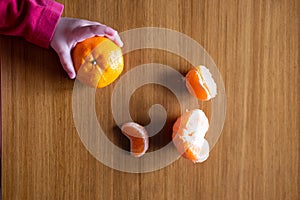 Baby s hand manipulating different fruits on a wooden table