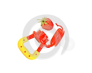 Baby`s nibbler and ripe strawberry on white background
