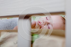 Baby`s restful sleep. Newborn baby in a wooden crib. The baby sleeps in the bedside cradle. Safe living together in a bedside cot