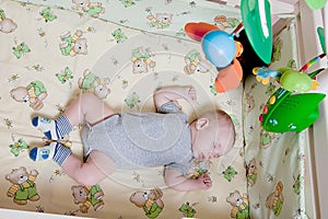 Baby`s restful sleep. Newborn baby in a wooden crib. The baby sleeps in the bedside cradle. Safe living together in a bedside cot