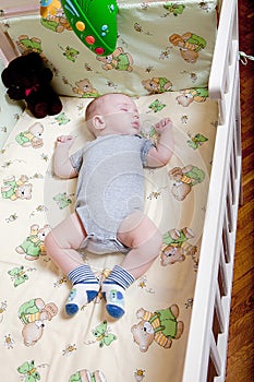 Baby`s restful sleep. Newborn baby in a wooden crib. The baby sleeps in the bedside cradle. Safe living together in a bedside cot