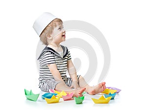 Baby sailor playing with paper boats