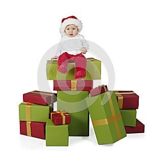 Baby seated on a stack of christmas presents