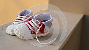 Baby shoes on blur outdoors background, closeup view