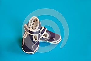 Baby shoes isolated on a blue background. Blue shoes for baby and copy space. Top view