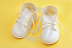 Baby shoes over yellow