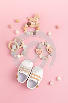 Baby shoes and teethers on pink background. Organic newborn fashion, branding, small business idea