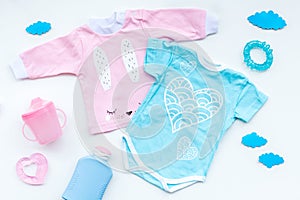 Baby shower concept. Baby`s clothes and accessories on light background top view