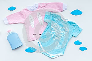 Baby shower concept. Baby`s clothes and accessories on light background top view