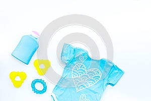 Baby shower concept. Baby`s clothes and accessories on white background top view copy space