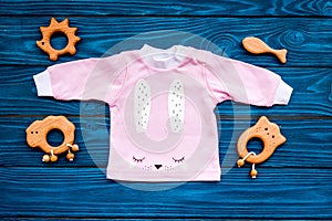 Baby shower concept. Baby`s clothes and toys on blue wooden background top view