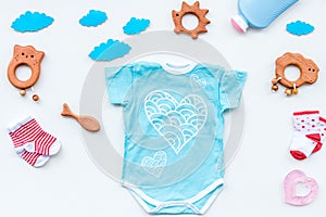 Baby shower concept. Baby`s clothes and toys on light background top view