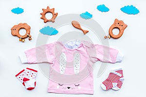 Baby shower concept. Baby`s clothes and toys on light background top view