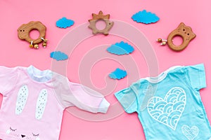 Baby shower concept. Baby`s clothes and toys on pink background top view