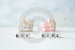 Baby shower ideas for a girl and boy party. Pink and blue decorative straw cradles with thread hearts and text BOY or GIRL.