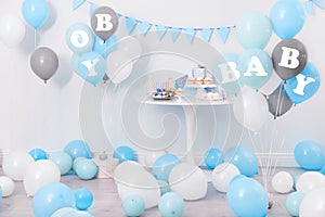 Baby shower party for boy. Treats in room decorated with balloons