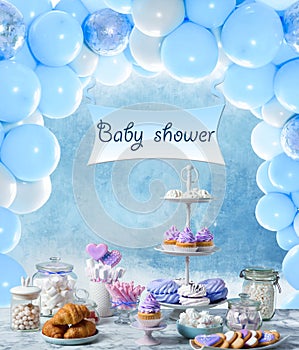 Baby shower party for boy. Tasty treats on table in room with balloons