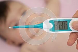 Baby sick with measuring electric thermometer. Child fever ill.