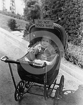 Baby with sign saying do not touch baby