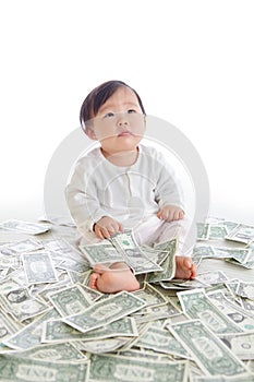 Baby sit on floor with many money