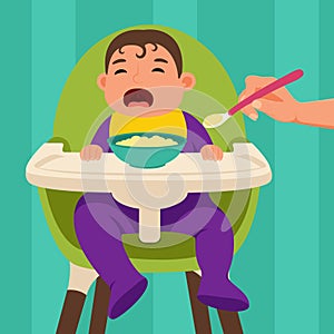 The baby sits in the feeding chair and refuses to eat when he is being fed.