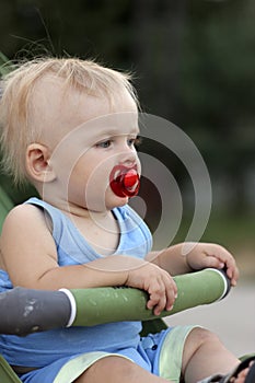 Baby sits in perambulator