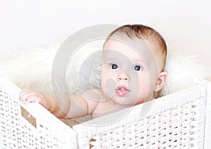 Baby sits in white basket