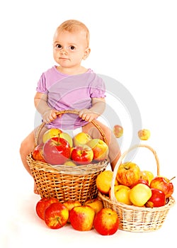 Baby sitting on apples basket