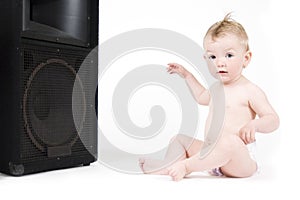 Baby sitting in front of loudspeaker photo