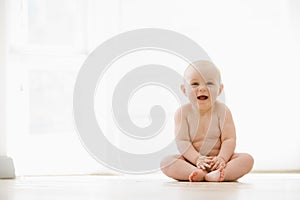 Baby sitting indoors smiling photo