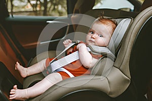 Baby sitting in safety rear-facing car seat photo