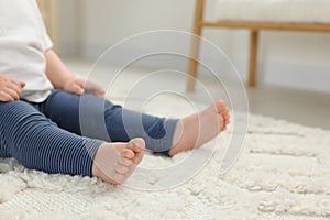 Baby sitting on soft carpet indoors, closeup. Space for text