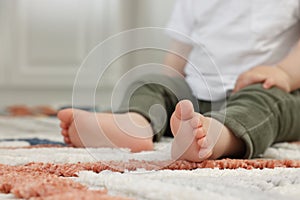 Baby sitting on soft carpet indoors, closeup. Space for text