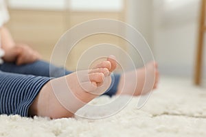 Baby sitting on soft carpet indoors, closeup. Space for text