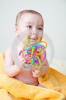 Baby Sitting on Yellow Towel Gnawing Toy photo