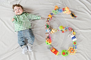 Baby six months top view. Happy baby in a hat and a diaper lying on the background of the carpet, smiling baby Toddler in a shirt