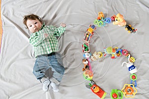 Baby six months top view. Happy baby in a hat and a diaper lying on the background of the carpet, smiling baby Toddler in a shirt