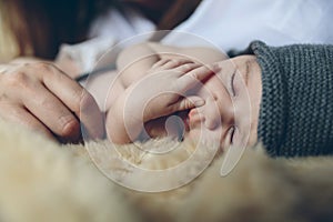Baby sleeping on a blanket with her mother`s hand