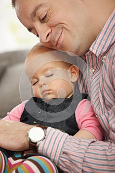 Baby sleeping in father's arm