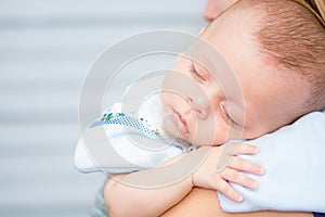 Baby sleeping on his mother`s shoulder