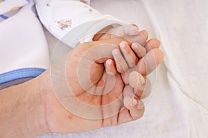 Baby sleeping and holding hand with father hand