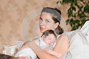 Baby sleeping with mom in her arms. Mom and newborn baby. Mom hugs and holds the newborn baby in her arms, the newborn sleeps in