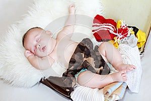 Baby sleeping in suitcase with clothes