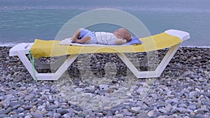 The baby sleeps on the beach